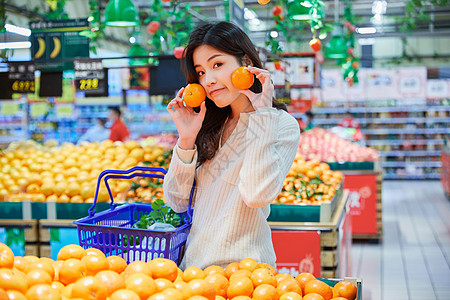 超市购物挑选橘子的青春女性图片