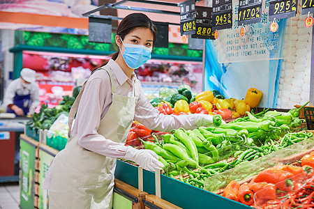 佩戴口罩的超市服务员整理蔬菜区图片