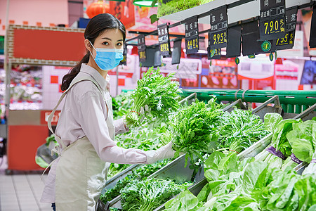 佩戴口罩的超市服务员整理蔬菜区图片