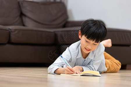 在家学习的小男孩写作业的人图片