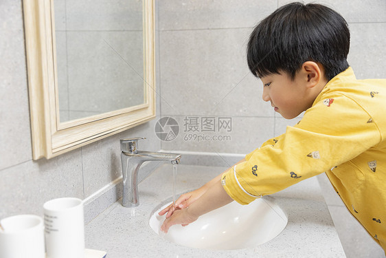 穿着睡衣的小男孩在浴室洗手图片