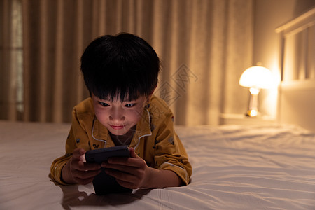 手绘儿童人物小男孩在黑暗中玩手机背景
