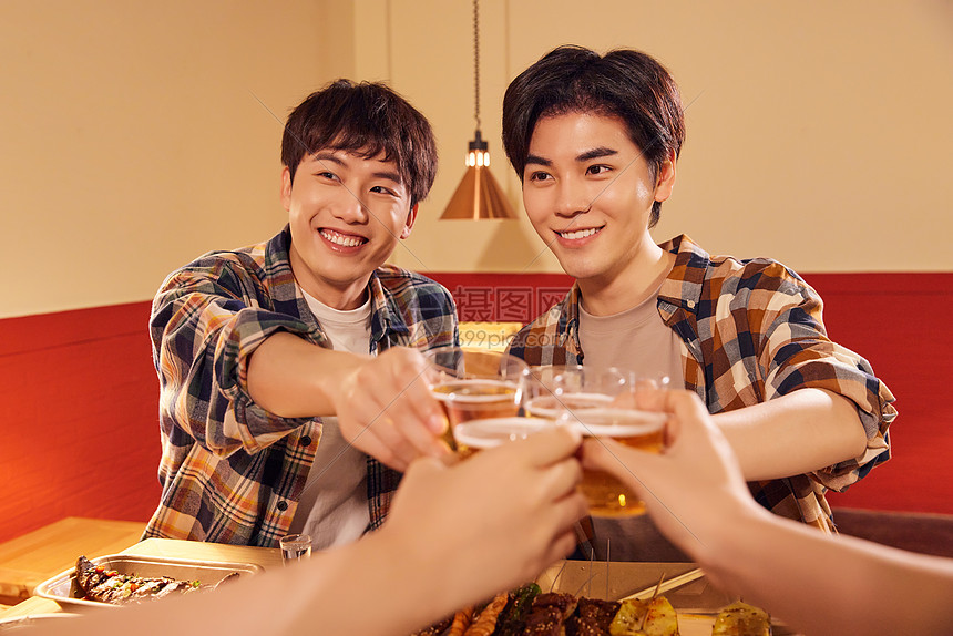 青年男性朋友欢乐喝啤酒撸串图片