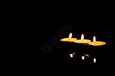 黑色背景燃烧的蜡烛图片