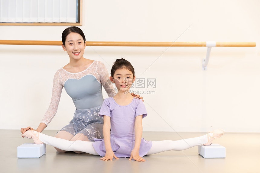 舞蹈老师帮助小女孩压腿