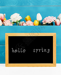 黑板上写着hello spring 和满是鲜花背景板图片