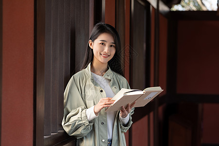 街拍人像美女游客大学生春游看书背景