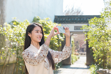 美女大学生旅行用手机拍照图片