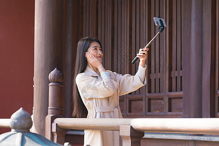 美女大学生旅行用手机拍照背景