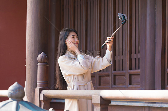 美女大学生旅行用手机拍照图片