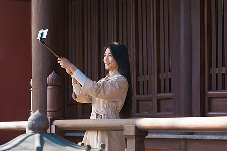 美女大学生旅行用手机拍照图片