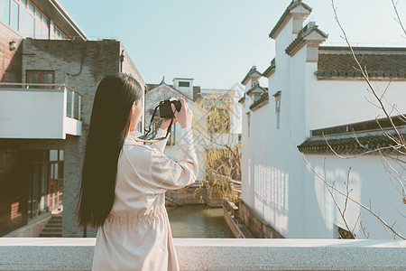 街拍青春美女大学生背着相机旅行拍照背景