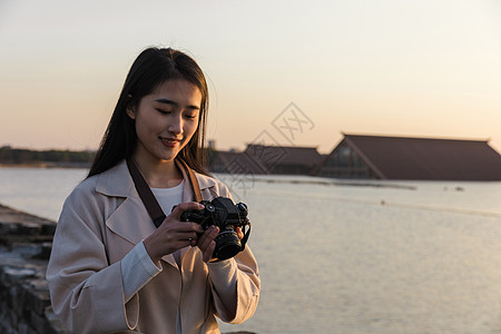 青春美女大学生背着相机旅行拍照背景图片