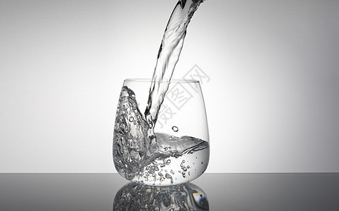 装满水的杯子往杯子里倒水背景