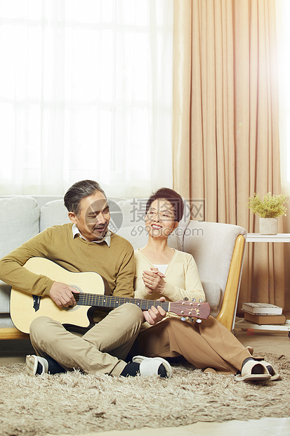 快乐的中老年夫妇在客厅弹吉他图片