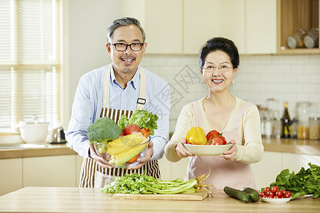 中老年夫妇手捧蔬菜水果高清图片