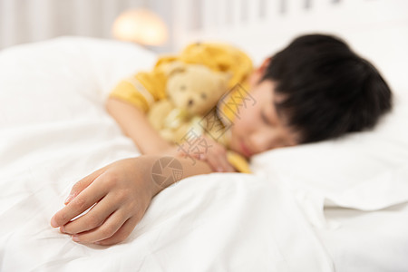 抱着桃子的男孩抱着小熊睡着的小男孩手部特写背景