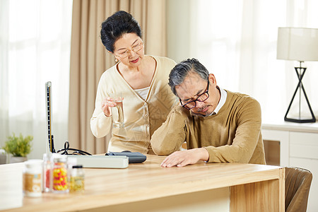 中老年女士辅助丈夫吃药图片