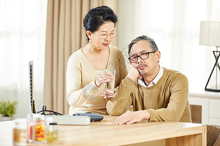 中老年女士辅助丈夫吃药图片