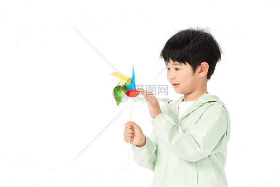 小男孩用手拨动玩具风车图片