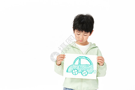 拿着手绘汽车的小男孩低头看图片