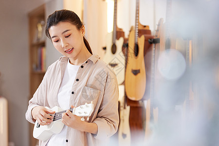 音乐培训班弹奏尤克里里的女性背景