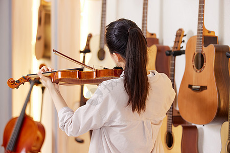 演奏小提琴的女性背影图片