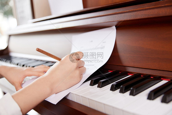 在钢琴前修改乐谱音乐创作图片