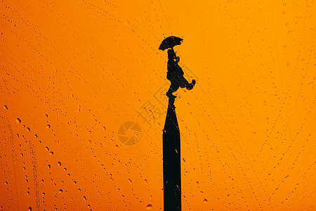 愚人节小丑节日背景-雨中撑伞的小丑图片