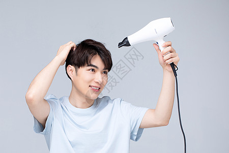 男生发型年轻男性使用吹风机做造型背景