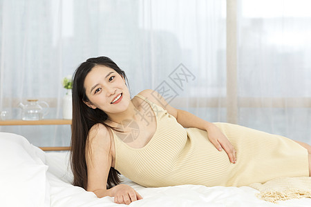 侧躺在床上的孕妇形象背景图片