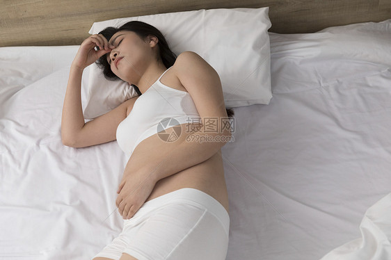躺在床上头疼的孕妇图片