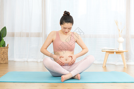 孕妇在瑜伽垫上摸肚子图片