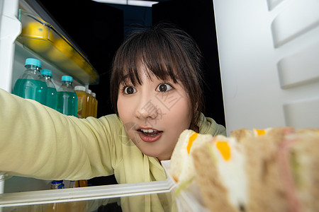 女性晚上打开冰箱找食物图片