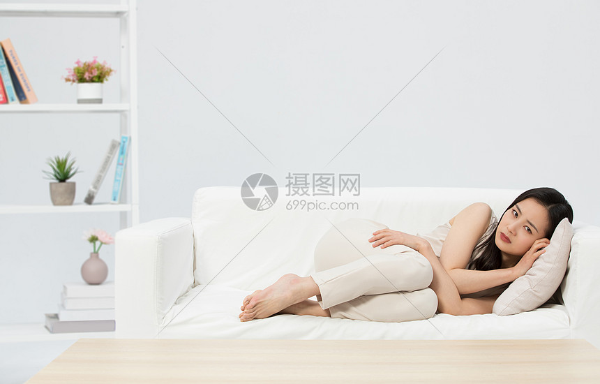 悲伤难过的女性躺在沙发
