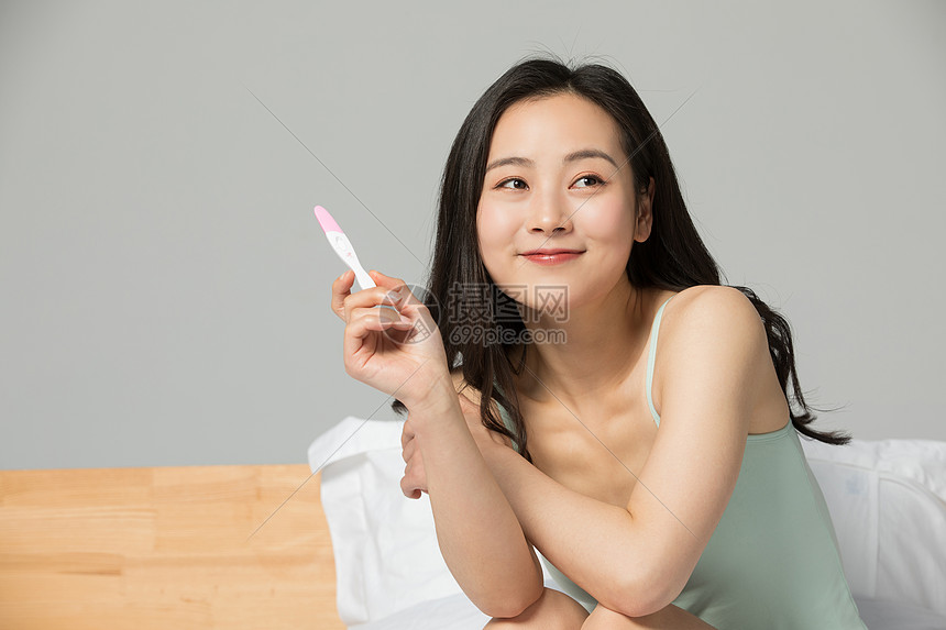 拿着验孕棒表情喜悦的女性图片