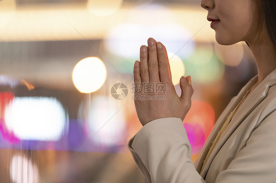 年轻女性双手合十祈祷许愿图片