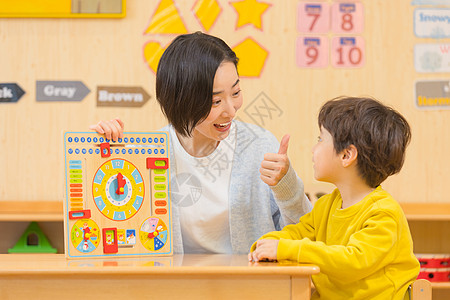 学生点赞幼儿园老师与小男孩玩玩具背景