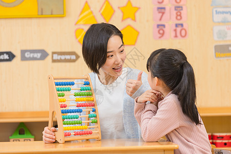 学生点赞幼儿园老师和小女孩玩玩具背景