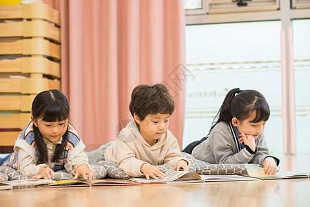 幼儿阅读小朋友们趴在地上看书背景