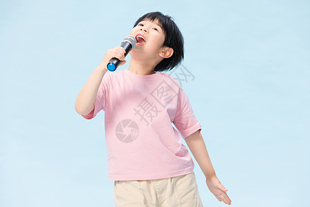 童真小男孩拿麦克风唱歌高清图片