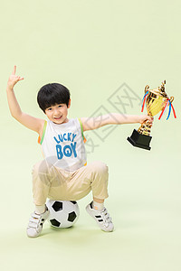 小男孩踢足球得奖杯图片