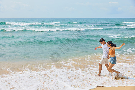 情侣散步年轻情侣海边旅行背景