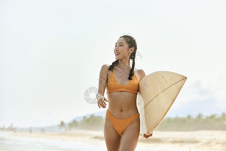 海边冲浪的女孩海边比基尼美女手拿冲浪板行走背景