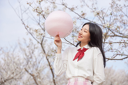 青春可爱美少女拿棉花糖逛游乐园图片