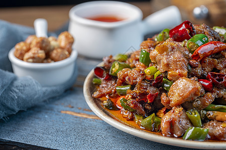木桌上盘子里的尖椒辣子鸡江湖菜高清图片素材