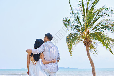 年轻情侣拥抱面向大海背影图片