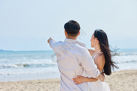 海滩背影年轻情侣牵手海边散步背影背景
