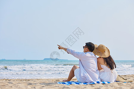 海边美女海边情侣坐在沙滩看大海背影背景