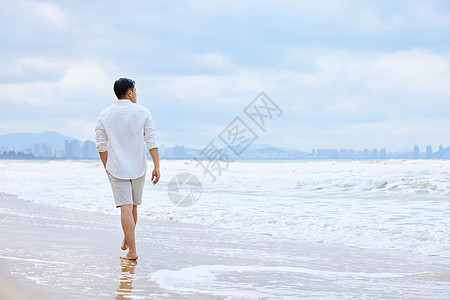 年轻男士夏天海边散步背影背景